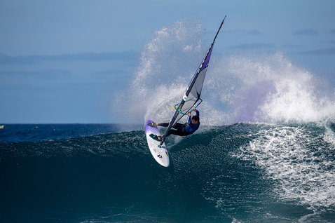 Duotone Ultra Grip [Quad] D/LAB windsurf board during wave riding in the ocean in dark navy blue
