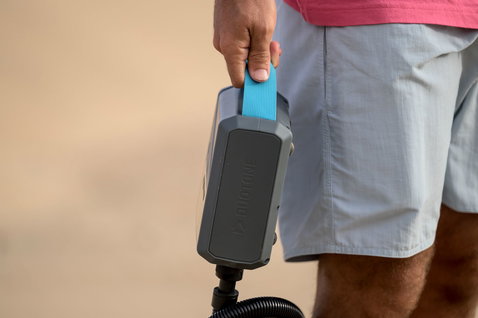 Duotone Lazepump elektrische Luftpumpe in dunkelgrau und cyan am Strand