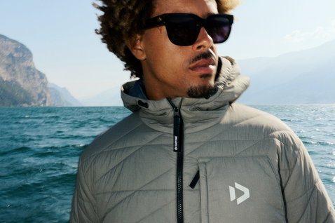 Duotone Explore insulated jacket in dusty sage green worn by a man at an alpine lake