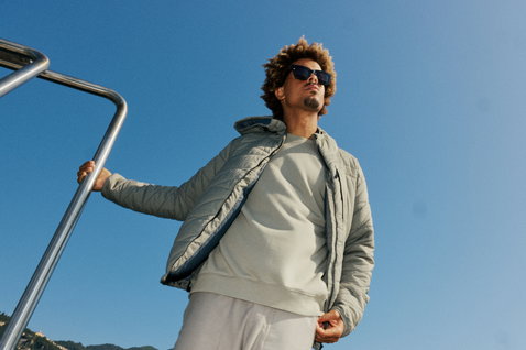 Duotone Explore insulated jacket in dusty forrest worn on a boat on a sunny day