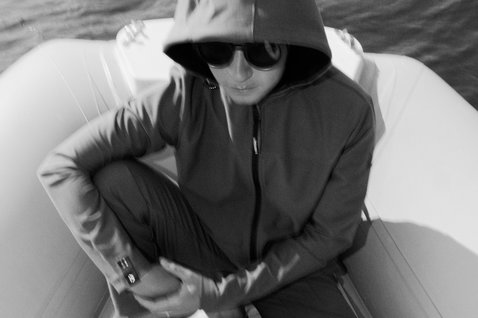 Sweat à capuche zippé Duotone Apparel Explore unisexe en gris foncé porté sur un bateau sur l'eau