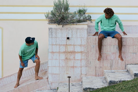Sweat à capuche unisexe Duotone Originals en vert menthe, porté par deux hommes sur des marches en pierre