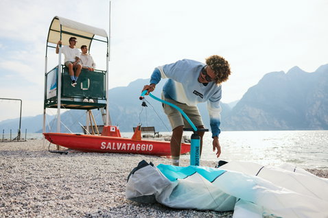 Sweat Duotone True homme en bleu clair dégradé dip-dye lors de la préparation au kitesurf au bord d'un lac de montagne