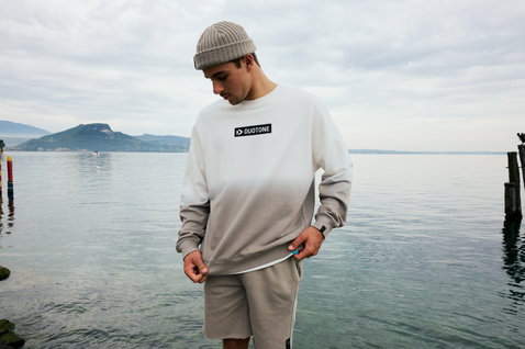 Sweat Duotone True homme avec dégradé dip-dye en blanc et gris poussiéreux porté au bord du lac