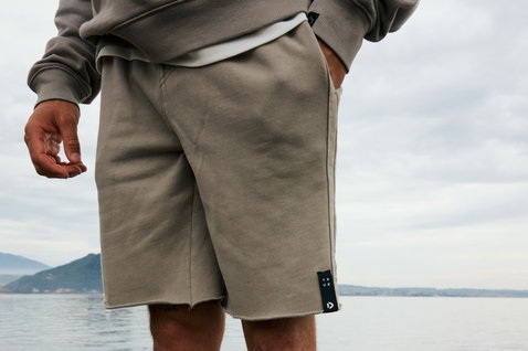 Short sweat Duotone True unisexe en taupe poussiéreux avec ourlet brut porté en extérieur au bord de l'eau