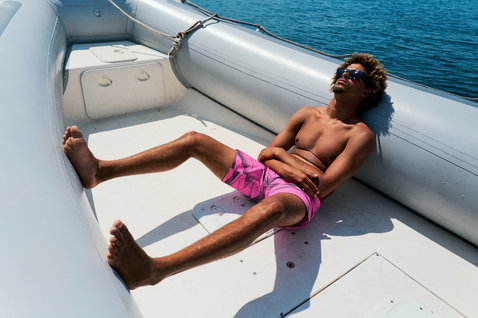 Duotone Originals boardshorts 19 pouces homme en rose lors d'une détente sur un bateau en mer