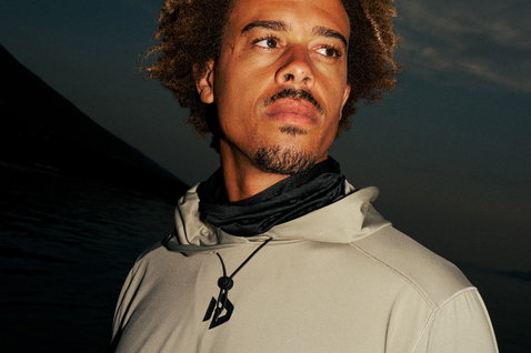 Duotone Longsleeve Wetshirt Guard homme rashguard manches longues à capuche en gris métal porté sur la plage au crépuscule