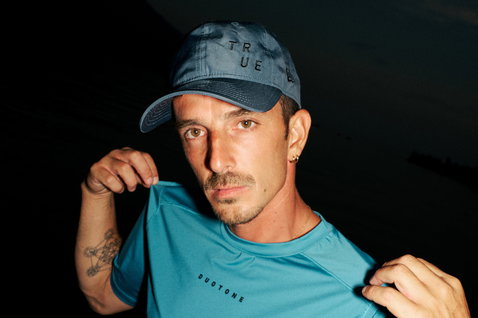 Cappellino tecnico regolabile Duotone New Era 9Twenty in blu-grigio scuro indossato da modello in scatto lifestyle