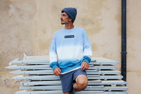 Bonnet Duotone Logo en gris slate porté par un homme dans un cadre urbain extérieur