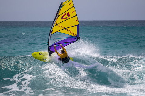 Duotone Grip [Tri] Windsurf-Board beim Wellenreiten im türkisblauen Ozean