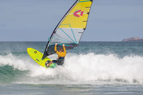Duotone Grip [Tri] SLS windsurf board during wave riding at the ocean beach