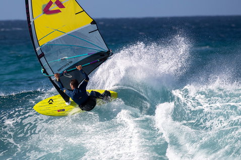 Duotone Ultra Grip [Quad] windsurf board during wave riding at an ocean wave break