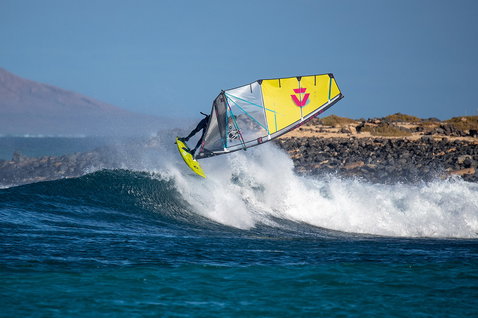 Duotone Ultra Grip [Quad] windsurf board during wave riding at a rocky Atlantic coastline