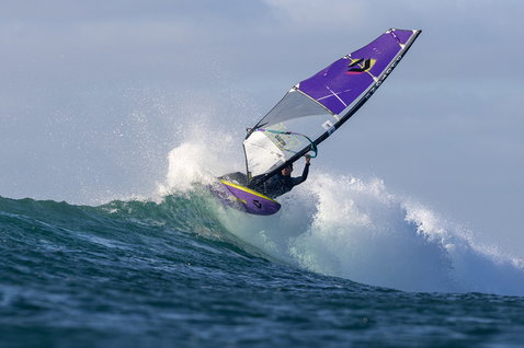 Duotone Ultra Grip [Quad] SLS windsurf board during wave riding at an ocean wave break