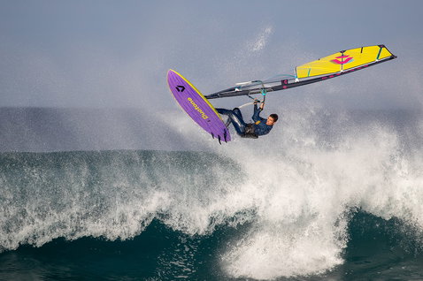 Duotone Ultra Grip SLS windsurf board during wave riding at ocean beach with breaking waves