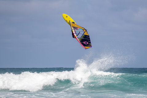 Duotone Duke Windsurf-Segel beim Wellenreiten am Ozeanstrand mit brechenden Wellen