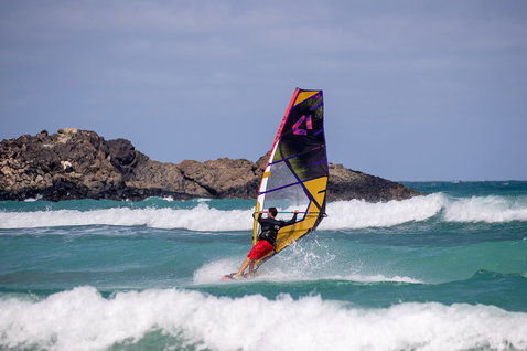 Duotone Duke Wave-Segel beim Wellenreiten am Meer mit felsigen Klippen