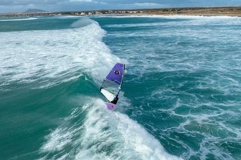 Duotone Super Hero D/LAB wave sail during windsurfing on the ocean beach