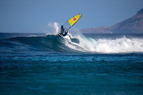 Duotone Super_Hero SLS wave windsurf sail during wave riding at an ocean beach