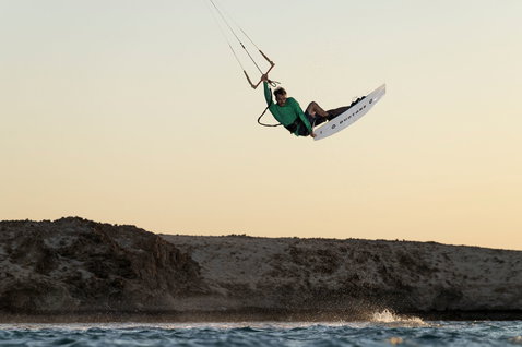 Duotone Click Bar Quad Control TS barre de contrôle lors d'une session de kitesurf dans une baie rocheuse côtière