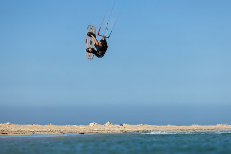 Duotone Trust Bar Jaime Quad Control barre lors de kitesurf sur plage océanique avec paysage côtier aride