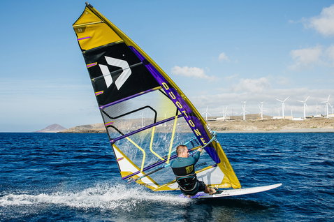 Duotone Warp_Fin voile de course 7,7 m² lors de la pratique du windsurf dans une baie côtière
