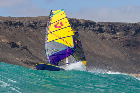 Duotone Duke SLS Wellenreitsegel beim Windsurfen an einer felsigen Meeresküste