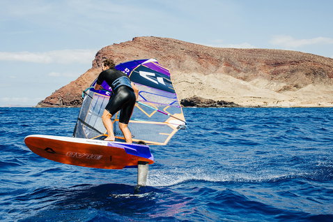 Duotone Falcon Foil D/LAB windsurf board during foiling at a rocky volcanic island coastline