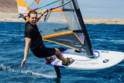 Duotone Falcon Foil D/LAB windsurf board during foiling at a rocky desert coastline