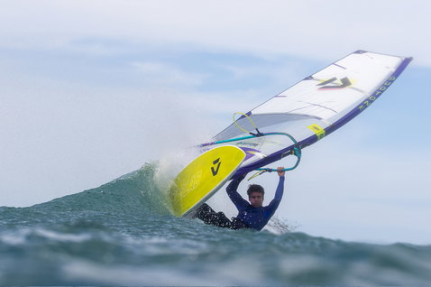Duotone Ultra Grip [Quad] D/LAB windsurf board during wave riding in the ocean in steel blue-grey