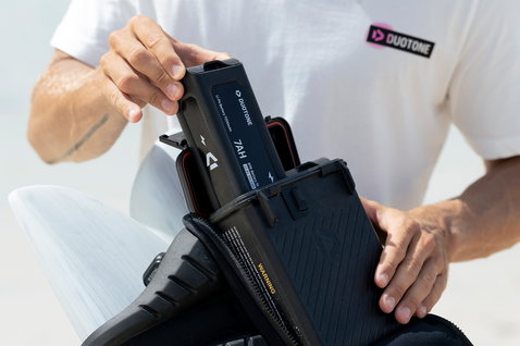 Duotone eHarness cintura con battery box in nero — dettaglio inserimento batteria in spiaggia