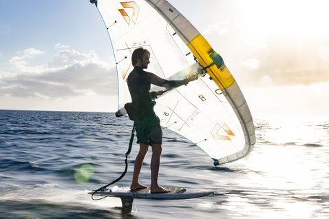 Duotone Unit SLS Foil Assist Set beim Wing Foiling auf dem Ozean im goldenen Abendlicht