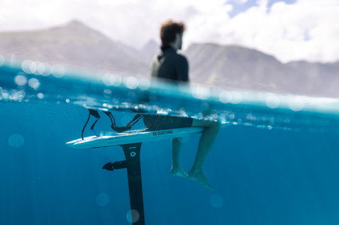 Duotone Midfish D/LAB planche de foil en action sur l'océan avec montagnes en arrière-plan