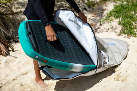 Duotone Sky Style Single Wing Boardbag in dunkelgrau mit weißem Innenfutter beim Einpacken eines Foilboards am Strand