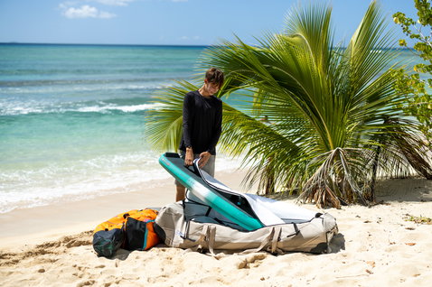 Duotone Team Bag Wing Boardtasche beim Auspacken an einem tropischen Strand mit türkisem Meer