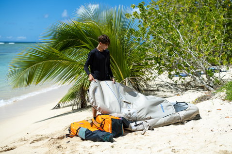 Duotone Wing Team Bag Flügel-Reisereisetasche beim Wing Foiling an einem tropischen Strand