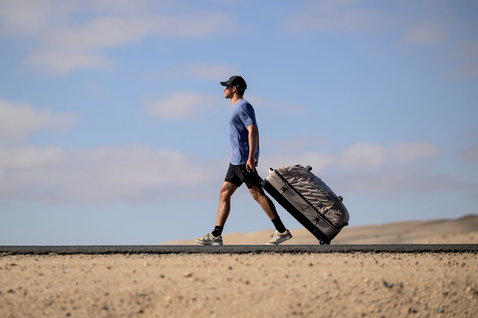 Duotone Travelbag sac de voyage lors d'un trajet sur une route désertique aride avec dunes