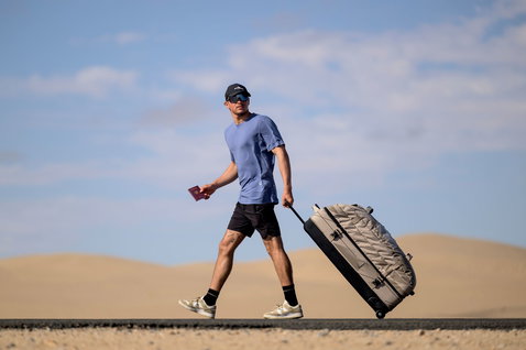 Duotone Travelbag sac de voyage lors d'un voyage sur une route désertique avec des dunes de sable
