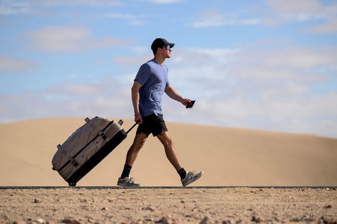 Duotone Travelbag sac de voyage lors d'une promenade dans le désert avec des dunes de sable