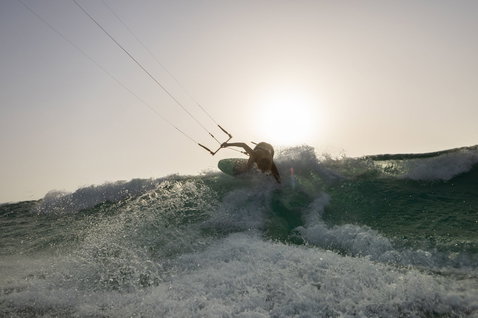 Duotone Whip SLS wave kiteboard during kitesurfing at the ocean beach