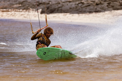 Duotone Whip SLS wave kiteboard during wave riding at ocean beach in shallow water near shore