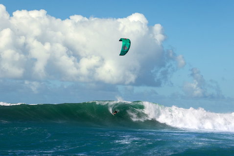 Duotone Blur D/LAB wave kiteboard durante surf de olas en un break de olas en océano abierto