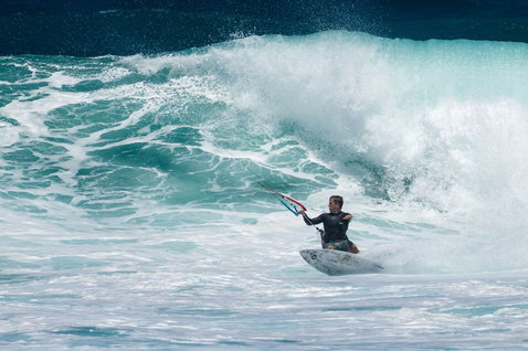 Duotone Blur D/LAB wave kiteboard durante el surf de olas en el océano con fuerte oleaje
