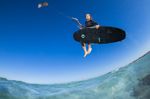 Duotone Provoke kiteboard strapless durante il kitesurf su una spiaggia oceanica