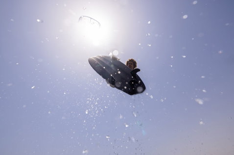 Duotone Provoke tavola da kitesurf freestyle senza strap durante il kitesurf con cielo aperto e spiaggia