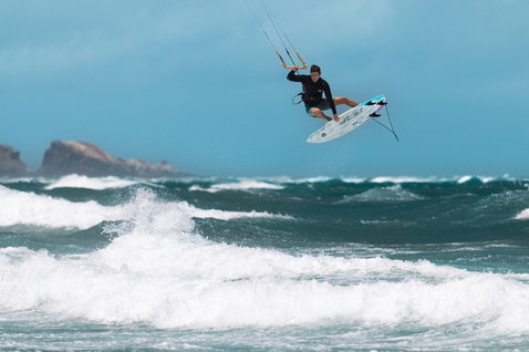 Planche de kitesurf Duotone Volt D/LAB lors de kitesurf sur plage avec promontoire rocheux