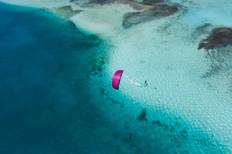 Duotone Dice SLS LEI Kite beim Kitesurfen in einer tropischen Lagune mit flachem Sand