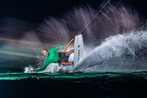 Duotone Dice SLS LEI Kite beim Kitesurfen auf dem Ozean bei Nacht