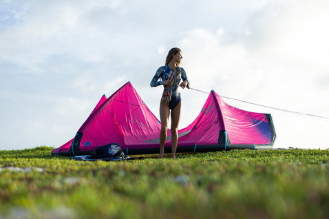 Duotone Dice SLS LEI Kite beim Kitesurfen an der Küste mit Strandgraslandschaft
