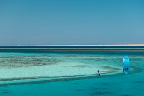 Duotone Soar SLS planche de kite foil en train de faire du foiling dans un lagon tropical peu profond avec banc de sable